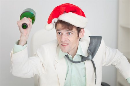 The young guy in a white jacket and a christmas hat brawls with a bottle in a hand Stock Photo - Budget Royalty-Free & Subscription, Code: 400-05178572