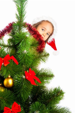 decorating small xmas tree - Lovely preschool girl hiding behind Christmas tree Stock Photo - Budget Royalty-Free & Subscription, Code: 400-05178631