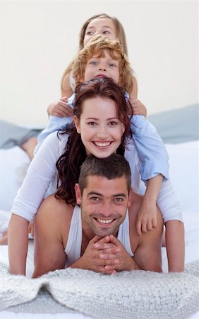 simsearch:400-04878558,k - Smiling father, mother, son and daughter in a mountain in bed Stock Photo - Budget Royalty-Free & Subscription, Code: 400-05179583