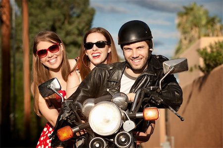 Three young adults posing on vintage motorcycle Stock Photo - Budget Royalty-Free & Subscription, Code: 400-05172662