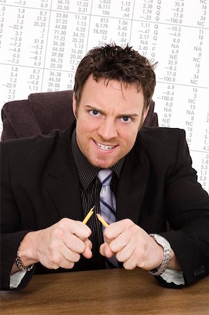 simsearch:400-04297320,k - Caucasian businessman setting at a desk and looking very angry and frustrated because of the Stock Market Stock Photo - Budget Royalty-Free & Subscription, Code: 400-05172769