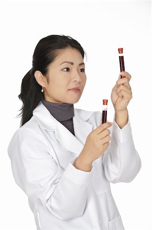 Beautiful Asian laboratory technician examining a tube of blood Stock Photo - Budget Royalty-Free & Subscription, Code: 400-05172785