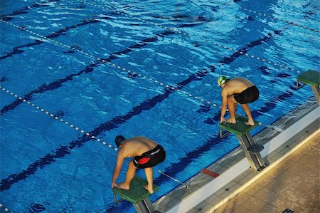 swim team - start position race concept with fit swimmer on swimming pool Stock Photo - Budget Royalty-Free & Subscription, Code: 400-05185127