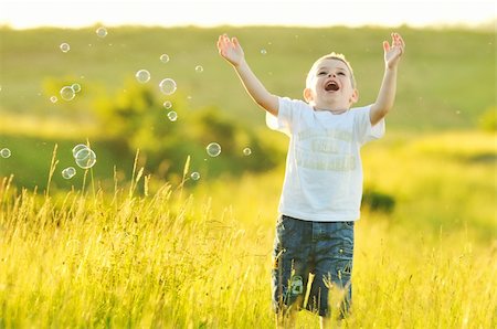 happy young beautiful child have fun on eadow with soap bubbles toy Stock Photo - Budget Royalty-Free & Subscription, Code: 400-05185409