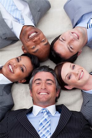Smiling business team lying on the floor with heads together. Business concept. Foto de stock - Super Valor sin royalties y Suscripción, Código: 400-05186145