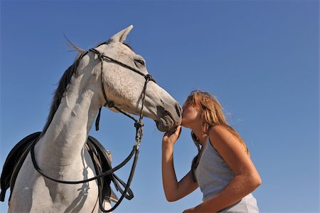 simsearch:400-04660370,k - young teenager kissing her gray arabian horse on a blue sky Photographie de stock - Aubaine LD & Abonnement, Code: 400-05186238