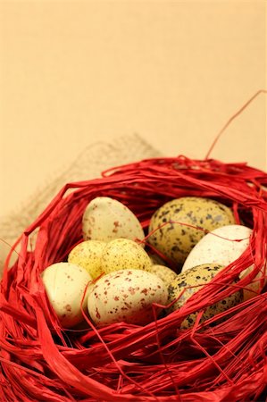 simsearch:400-04291976,k - Quail Easter eggs in a red nest, light brown background. Shallow DOF, copy space Photographie de stock - Aubaine LD & Abonnement, Code: 400-05186298