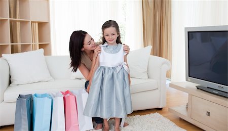 simsearch:400-04323202,k - Mother and her girl trying on a dress after shopping in the living-room Stock Photo - Budget Royalty-Free & Subscription, Code: 400-05186309