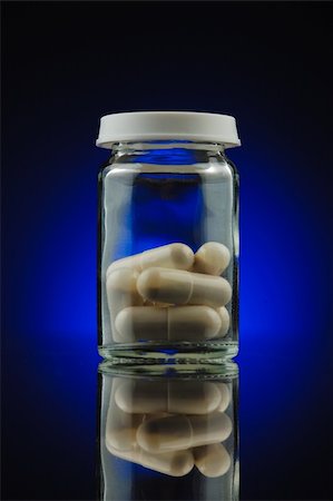 Clear bottle with pills on blue background Photographie de stock - Aubaine LD & Abonnement, Code: 400-05180000