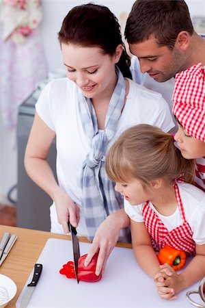 Mother cutting vegetables in kitchen with her family Stock Photo - Budget Royalty-Free & Subscription, Code: 400-05180102