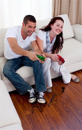 Happy couple playing video games in living-room Stock Photo - Budget Royalty-Free & Subscription, Code: 400-05180111