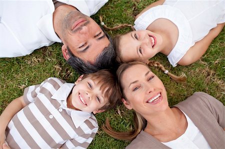 Smiling family lying in a park with heads together Stock Photo - Budget Royalty-Free & Subscription, Code: 400-05180193