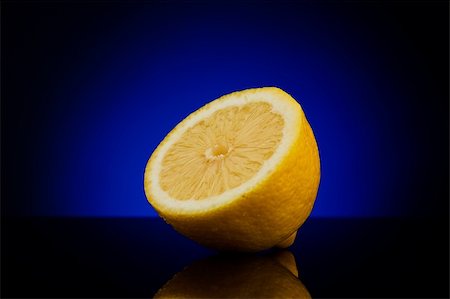 simsearch:400-05057164,k - Fresh half of lemon isolated on dark background with blue gradient Fotografie stock - Microstock e Abbonamento, Codice: 400-05181668