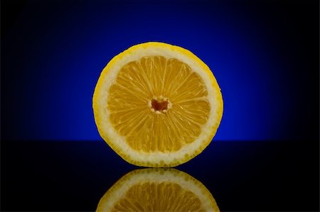 simsearch:400-05057164,k - Fresh half of lemon facing foward isolated on dark background with blue gradient Fotografie stock - Microstock e Abbonamento, Codice: 400-05181671