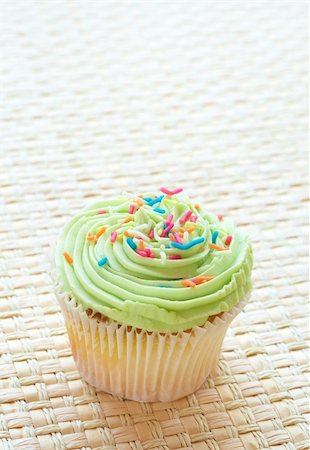 simsearch:400-05316582,k - Fresh vanilla cupcake with green lime icing on woven straw background Stock Photo - Budget Royalty-Free & Subscription, Code: 400-05196267