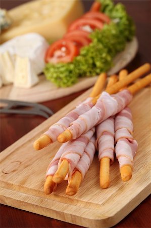 emmentaler cheese - Bacon wrapped grissini breadsticks and cheese board in background Stock Photo - Budget Royalty-Free & Subscription, Code: 400-05196504