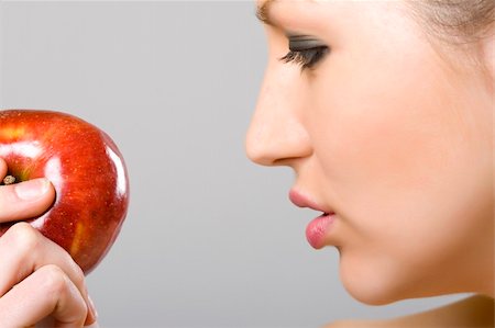 closeup picture of a woman looking at an apple Photographie de stock - Aubaine LD & Abonnement, Code: 400-05197105