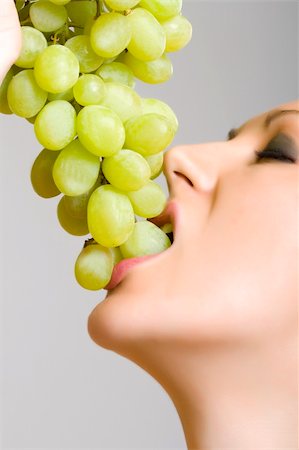 photo of model woman with grapes - closeup picture of a woman biting a grape Stock Photo - Budget Royalty-Free & Subscription, Code: 400-05197106