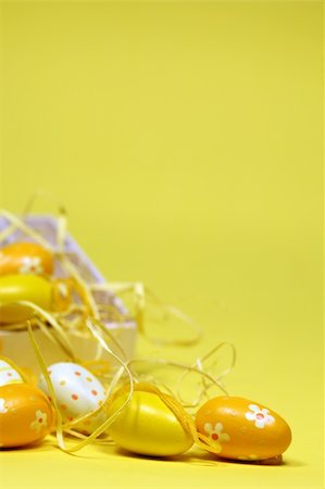 simsearch:400-04291976,k - Yellow Easter eggs with a box and some straws. Shallow dof, copy space Photographie de stock - Aubaine LD & Abonnement, Code: 400-05198289