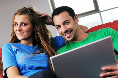happy young couple have fun and relax at comfort bright apartment and work on laptop computerhappy young couple have fun and relax at comfort bright appartment and work on laptop computer Stock Photo - Budget Royalty-Free & Subscription, Code: 400-05190577