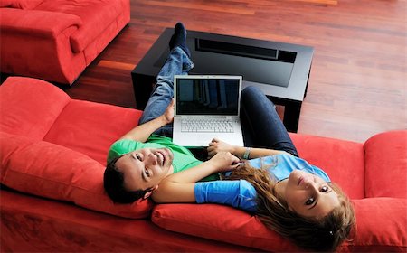 happy young couple have fun and relax at comfort bright apartment and work on laptop computerhappy young couple have fun and relax at comfort bright appartment and work on laptop computer Stock Photo - Budget Royalty-Free & Subscription, Code: 400-05190578