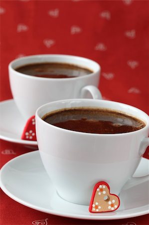 Caps of coffee with little ceramic hearts on red background. Shallow dof, copy space Stock Photo - Budget Royalty-Free & Subscription, Code: 400-05191521