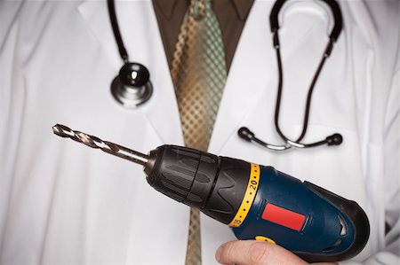 Doctor with Stethoscope Holding A Very Big Drill. Stock Photo - Budget Royalty-Free & Subscription, Code: 400-05192290