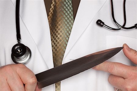 Doctor with Stethoscope Holding A Very Large Knife. Stock Photo - Budget Royalty-Free & Subscription, Code: 400-05192323
