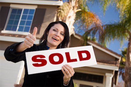 Happy Attractive Hispanic Woman with Thumbs Up Holding Sold Sign In Front of House. Stock Photo - Budget Royalty-Free & Subscription, Code: 400-05193542