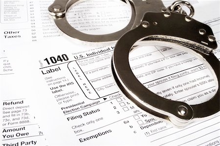 simsearch:400-05339747,k - Stock image of handcuffs over Tax forms, concepts: Tax fraud or Slave to the Taxes Photographie de stock - Aubaine LD & Abonnement, Code: 400-05193787