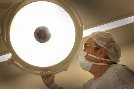 simsearch:400-04177437,k - Surgeon moving the surgical reflector at the  operating room Photographie de stock - Aubaine LD & Abonnement, Code: 400-05204948