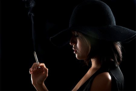 Pretty girl smokes a cigarette in the dark Photographie de stock - Aubaine LD & Abonnement, Code: 400-05205614