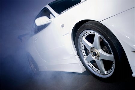 sports car moving luxury - car pulling a wheelspin on the tarmac creating a cloud of smoke Stock Photo - Budget Royalty-Free & Subscription, Code: 400-05205957