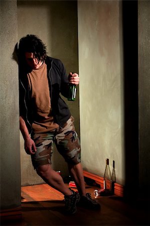 simsearch:400-06558618,k - Drunk young man leaning on a wall with beer bottle Photographie de stock - Aubaine LD & Abonnement, Code: 400-05208145