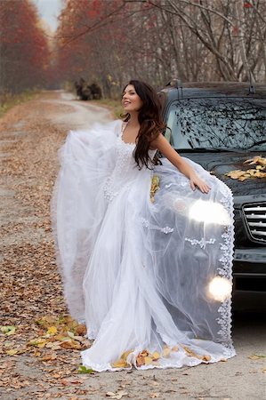simsearch:400-05208182,k - Young woman in a wedding dress standing near the jeep in an autumn forest Foto de stock - Royalty-Free Super Valor e Assinatura, Número: 400-05208189