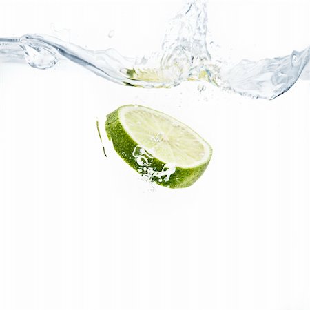 lime slice splashing into water with white background Photographie de stock - Aubaine LD & Abonnement, Code: 400-05209144
