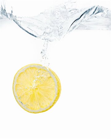 lemon slice splashing into water with white background Stock Photo - Budget Royalty-Free & Subscription, Code: 400-05209143