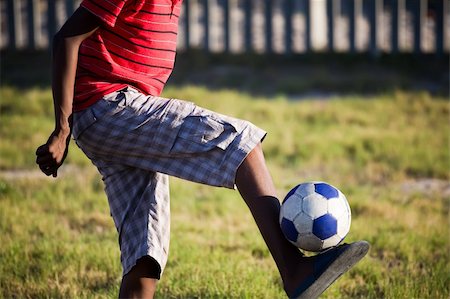 simsearch:400-04325504,k - A teenage boy with only his legs in shot holding a soccer ball up with just his feet Fotografie stock - Microstock e Abbonamento, Codice: 400-05209599