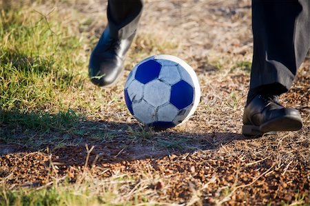 simsearch:400-04325504,k - A man with only his feet in shot kicking a blue and white soccer ball Fotografie stock - Microstock e Abbonamento, Codice: 400-05209601