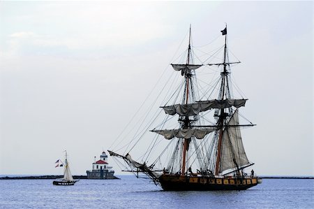 paradise harbour - 214 ft Niagara Tall ship coming into Harbor, passing a small sailboat and lighthouse. Sails draped on the mast, beautiful blue water Photographie de stock - Aubaine LD & Abonnement, Code: 400-05200668