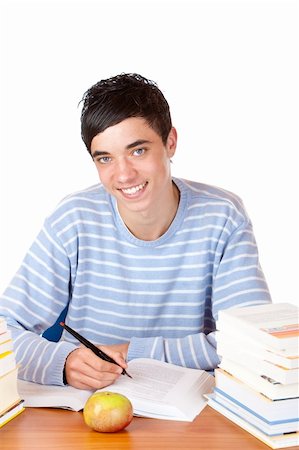 simsearch:400-04704759,k - Young student is sitting on desk with study books and learns for his exams. He smiles happy into camera. Isolated on white. Stock Photo - Budget Royalty-Free & Subscription, Code: 400-05201067