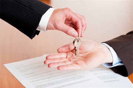 shaking hands investment - One businessman overgives a house or car key another businessmen. In background is a contract visible. Stock Photo - Budget Royalty-Free & Subscription, Code: 400-05201073