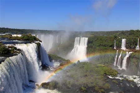 Iguazu waterfalls with rainbow on a sunny day. The largest waterfall on earth Fotografie stock - Microstock e Abbonamento, Codice: 400-05203606