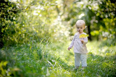 simsearch:400-04067084,k - Little baby in a forest holding yellow leaf and looking at it Stock Photo - Budget Royalty-Free & Subscription, Code: 400-05215029