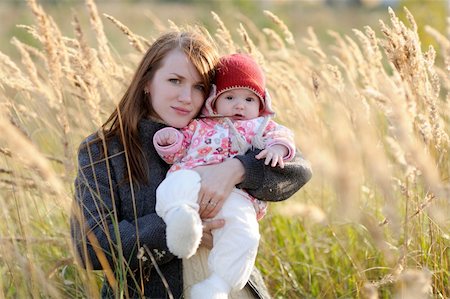 simsearch:400-04825533,k - Young mother holding her little baby in a meadow Stock Photo - Budget Royalty-Free & Subscription, Code: 400-05215033