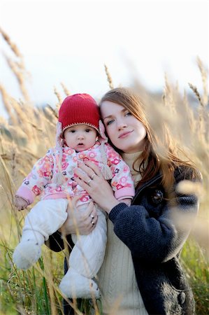 simsearch:400-04825533,k - Young mother is holding her little baby walking in a meadow Stock Photo - Budget Royalty-Free & Subscription, Code: 400-05215041