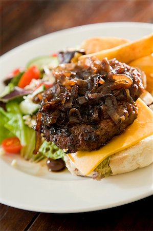 simsearch:700-06714108,k - Grilled Beef patty, topped with caramelised onions, on slice of rich cheddar cheese, with fresh Greek salad, fried potato chips. Stock Photo - Budget Royalty-Free & Subscription, Code: 400-05215861