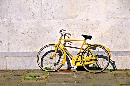 simsearch:400-08531186,k - Yellow bicycle  with flat tyres, leaning against a marble wall in Pisa, Italy. Foto de stock - Super Valor sin royalties y Suscripción, Código: 400-05216845