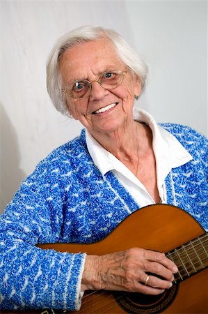 elderly person singing - Elderly woman playing the guitar wearing a blue knitted top. Stock Photo - Budget Royalty-Free & Subscription, Code: 400-05217670