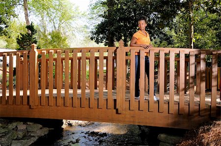 A beautiful young black woman hiking over a bridge Stock Photo - Budget Royalty-Free & Subscription, Code: 400-05218468